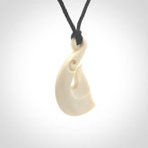 Hand carved bone whale tail pendant with black adjustable cord.